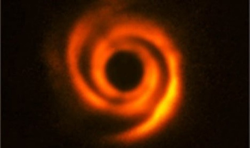 Ученые обнаружили странную звездную систему со спиральными рукавами, внутри которой скрывается планета